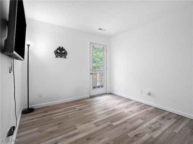 1217 W River Rd N Unit A3, Elyria, OH 44035 - spare room with light wood-style flooring and a textured ceiling