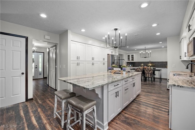 26938 Tall Oaks Trl, Olmsted Twp, OH 44138 - kitchen with a chandelier, white cabinets, backsplash, a kitchen island, and recessed lighting