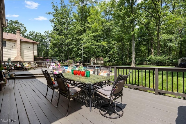 26938 Tall Oaks Trl, Olmsted Twp, OH 44138 - wooden deck featuring outdoor dining area, a yard, view of scattered trees, and a shed