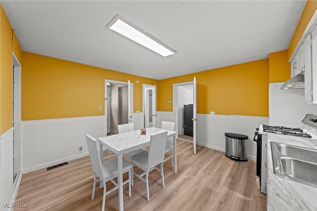 1411 E 47th St, Cleveland, OH 44103 - dining area featuring wainscoting and light wood finished floors