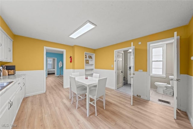 1411 E 47th St, Cleveland, OH 44103 - dining area with light wood finished floors and wainscoting
