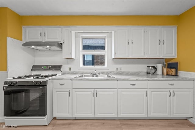 1411 E 47th St, Cleveland, OH 44103 - kitchen with range with gas stovetop, under cabinet range hood, white cabinets, and light countertops