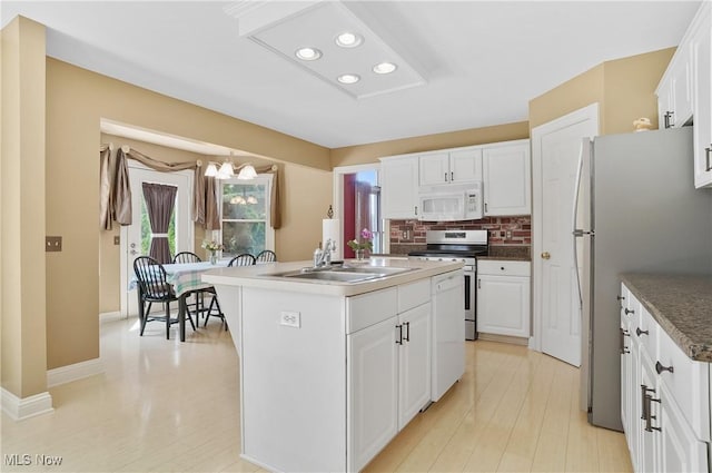 8883 Michaels Ln, Broadview Heights, OH 44147 - kitchen with white microwave, stainless steel electric range oven, a kitchen island with sink, freestanding refrigerator, and white cabinetry