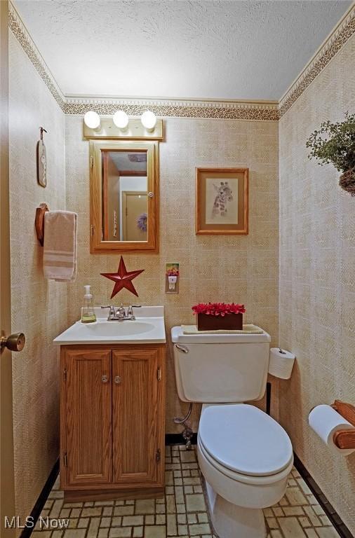 6122 Forest Ridge Dr, North Olmsted, OH 44070 - bathroom featuring vanity, wallpapered walls, and a textured ceiling