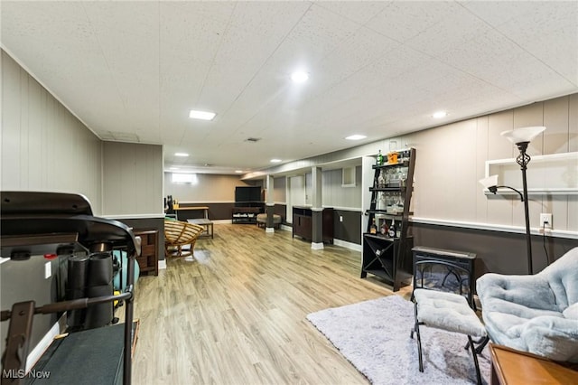 129 Whitman Blvd, Elyria, OH 44035 - living room featuring wood finished floors, a wood stove, a decorative wall, and recessed lighting