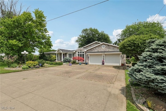 1318 Mirheath Dr, Huron, OH 44839 - ranch-style house featuring stone siding, an attached garage, and driveway