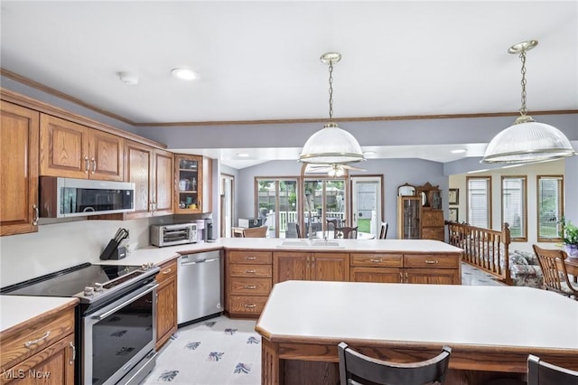 1318 Mirheath Dr, Huron, OH 44839 - kitchen with appliances with stainless steel finishes, brown cabinets, a peninsula, light countertops, and decorative light fixtures