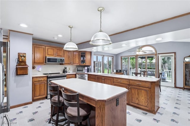 1318 Mirheath Dr, Huron, OH 44839 - kitchen featuring stainless steel appliances, a kitchen island, a peninsula, brown cabinetry, and recessed lighting