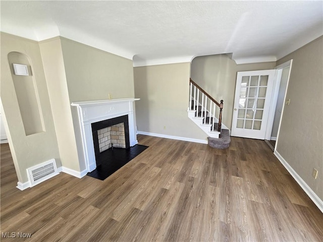 26313 Oriole Ave, Euclid, OH 44132 - unfurnished living room with a fireplace with flush hearth, stairway, and wood finished floors