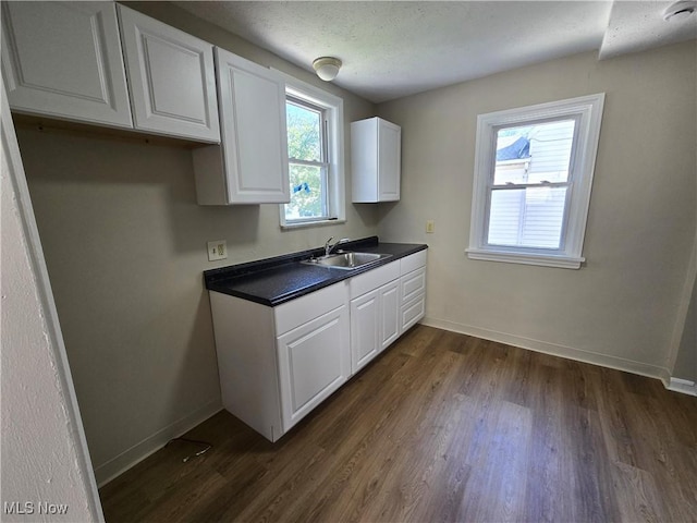 26313 Oriole Ave, Euclid, OH 44132 - kitchen with dark countertops, white cabinetry, and dark wood-type flooring