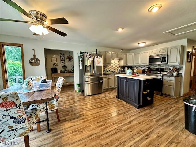 4145 Old River Rd, Philo, OH 43771 - kitchen with stainless steel appliances, backsplash, light wood finished floors, a center island, and a ceiling fan