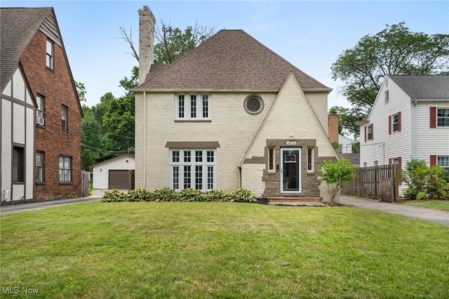 18112 Lomond Blvd, Shaker Heights, OH 44122 - view of front of property featuring a chimney, an outbuilding, brick siding, roof with shingles, and a detached garage