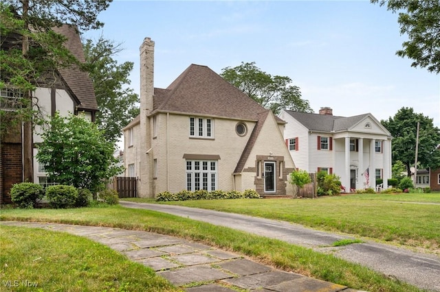 18112 Lomond Blvd, Shaker Heights, OH 44122 - view of front of house with a chimney, brick siding, and a front lawn