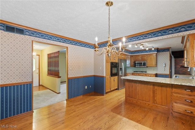 120 Vineyard Way, Doylestown, OH 44230 - kitchen with appliances with stainless steel finishes, a wainscoted wall, crown molding, wallpapered walls, and a chandelier