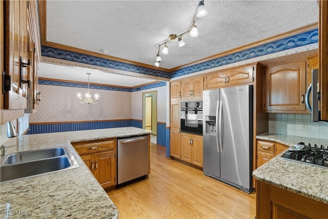 120 Vineyard Way, Doylestown, OH 44230 - kitchen with appliances with stainless steel finishes, wallpapered walls, ornamental molding, light wood-style flooring, and a chandelier