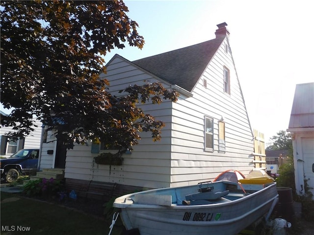 3233 Wilson Ave, Ashtabula, OH 44004 - view of home's exterior with a chimney, entry steps, and a shingled roof