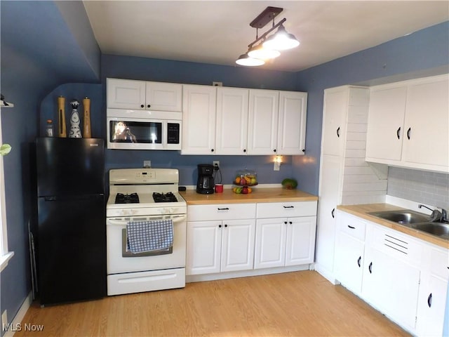 3233 Wilson Ave, Ashtabula, OH 44004 - kitchen featuring white appliances, light wood finished floors, light countertops, and white cabinetry