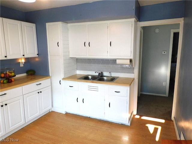 3233 Wilson Ave, Ashtabula, OH 44004 - kitchen featuring white cabinets, light wood-style floors, light countertops, and tasteful backsplash
