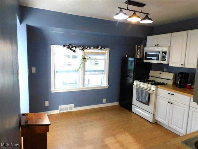 3233 Wilson Ave, Ashtabula, OH 44004 - kitchen featuring white range with gas stovetop, stainless steel microwave, white cabinets, and light wood-type flooring