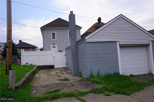 124 Peeler St, Mingo Junction, OH 43938 - back of house with a gate, a garage, an outbuilding, and a chimney