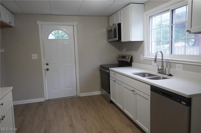 124 Peeler St, Mingo Junction, OH 43938 - kitchen featuring appliances with stainless steel finishes, light wood-style flooring, white cabinetry, and light countertops