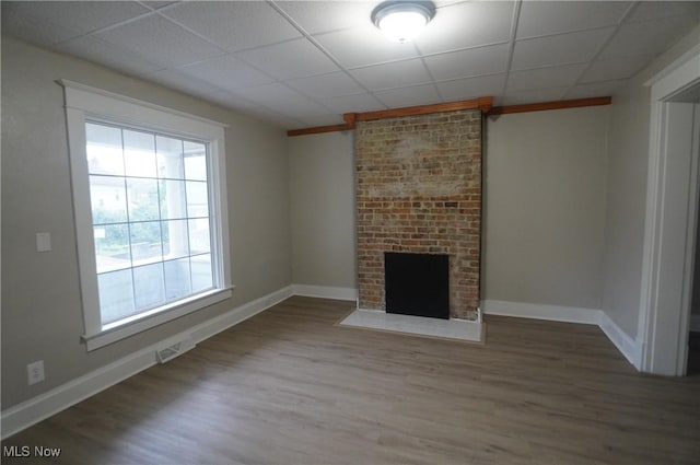 124 Peeler St, Mingo Junction, OH 43938 - unfurnished living room featuring wood finished floors, a drop ceiling, and a brick fireplace