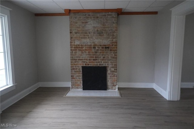124 Peeler St, Mingo Junction, OH 43938 - unfurnished living room with a drop ceiling, wood finished floors, and a fireplace