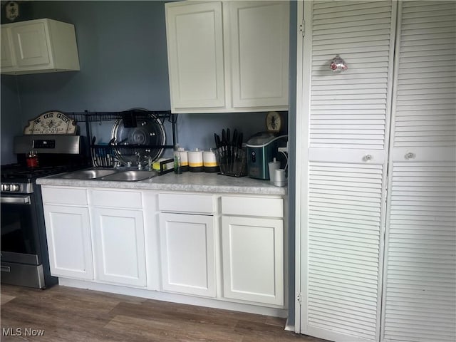 1540 Tanner Ave SW, Canton, OH 44706 - kitchen with stainless steel stove, white cabinets, dark wood finished floors, and light countertops