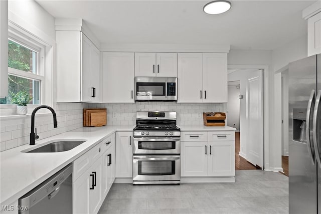 1361 Plainfield Rd, South Euclid, OH 44121 - kitchen featuring stainless steel appliances, white cabinetry, light countertops, and backsplash