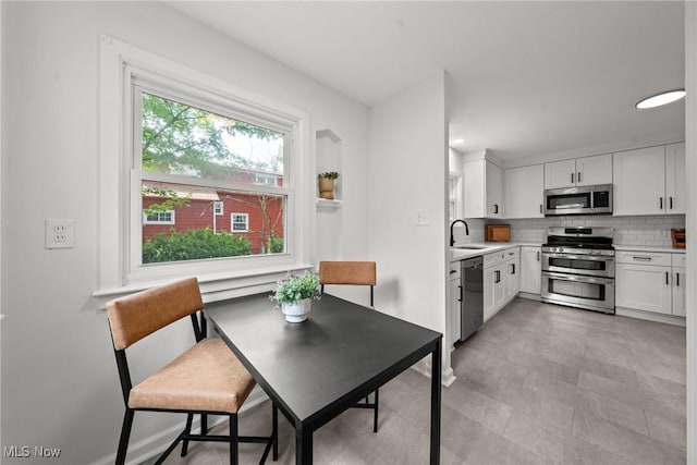 1361 Plainfield Rd, South Euclid, OH 44121 - kitchen with appliances with stainless steel finishes, light countertops, tasteful backsplash, and white cabinets