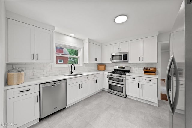 1361 Plainfield Rd, South Euclid, OH 44121 - kitchen with appliances with stainless steel finishes, light countertops, white cabinetry, decorative backsplash, and recessed lighting