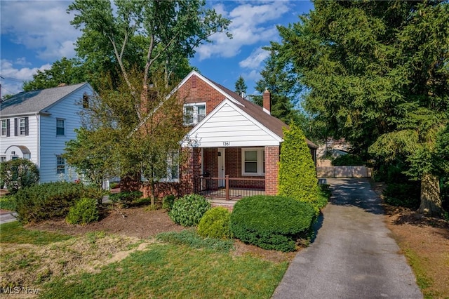 1361 Plainfield Rd, South Euclid, OH 44121 - bungalow with brick siding, covered porch, and a chimney