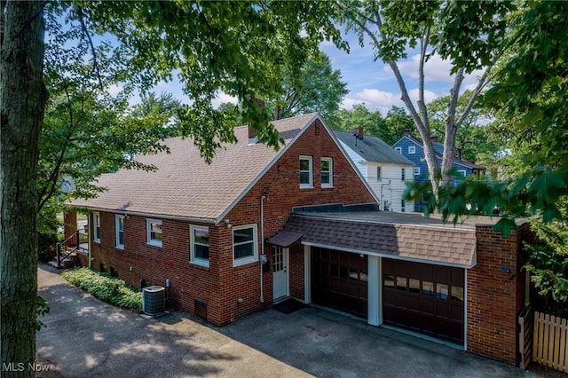 1361 Plainfield Rd, South Euclid, OH 44121 - tudor home featuring roof with shingles, brick siding, and a garage