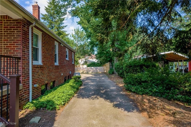 1361 Plainfield Rd, South Euclid, OH 44121 - view of side of property featuring brick siding, driveway, and a chimney