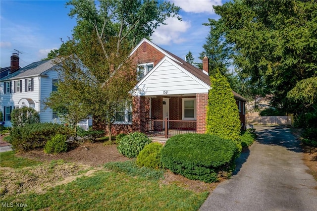 1361 Plainfield Rd, South Euclid, OH 44121 - bungalow-style house with brick siding, driveway, a porch, and a chimney