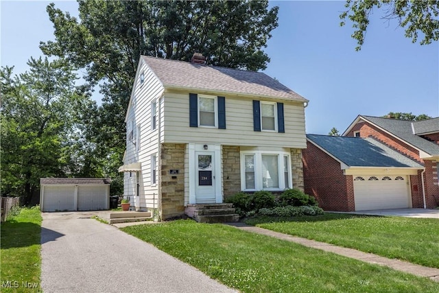 234 E 218th St, Euclid, OH 44123 - colonial house with stone siding, a front lawn, a chimney, an outbuilding, and an attached garage