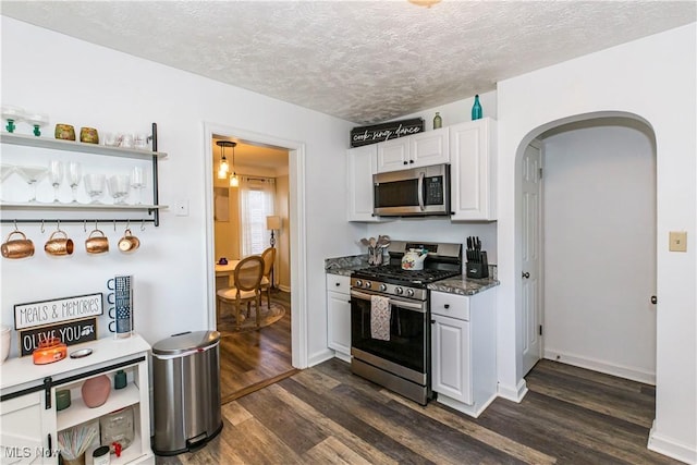 234 E 218th St, Euclid, OH 44123 - kitchen with stainless steel appliances, arched walkways, dark wood-style flooring, a textured ceiling, and white cabinetry