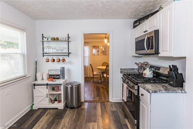 234 E 218th St, Euclid, OH 44123 - kitchen featuring stainless steel appliances, dark wood-style flooring, white cabinets, a textured ceiling, and dark stone countertops