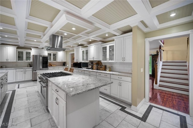 8985 Williams Rd, Chardon, OH 44024 - kitchen with stainless steel appliances, range hood, a center island, white cabinets, and coffered ceiling