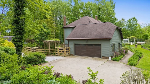 8985 Williams Rd, Chardon, OH 44024 - view of side of property with a chimney, roof with shingles, and a detached garage