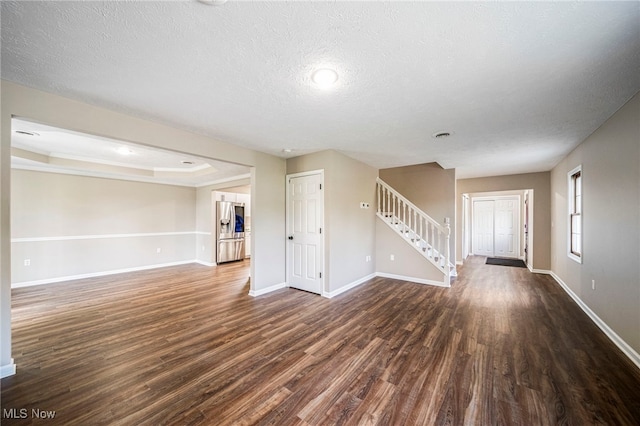 5411 W Heisley Rd, Mentor, OH 44060 - unfurnished living room with stairway, dark wood-style floors, and a textured ceiling
