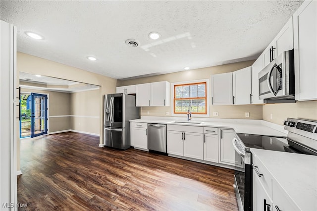 5411 W Heisley Rd, Mentor, OH 44060 - kitchen featuring stainless steel appliances, a textured ceiling, dark wood-style floors, white cabinetry, and light countertops