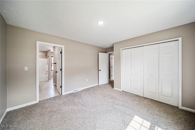 5411 W Heisley Rd, Mentor, OH 44060 - unfurnished bedroom featuring light carpet, a closet, ensuite bath, and light tile patterned floors