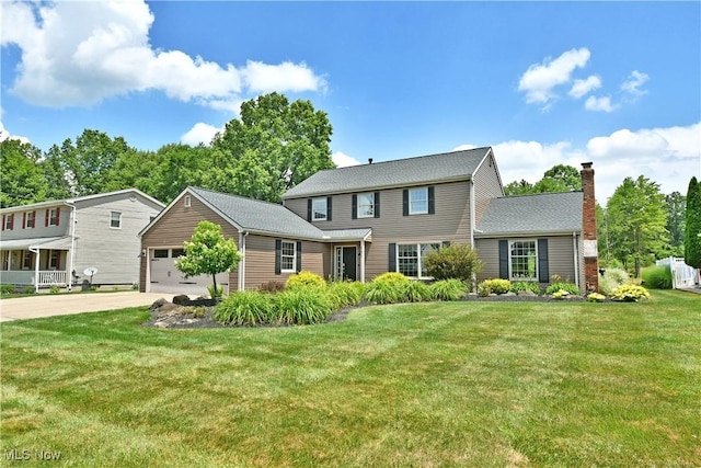 191 Maple Leaf Dr, Hubbard, OH 44425 - colonial home featuring driveway, an attached garage, a front lawn, and a chimney