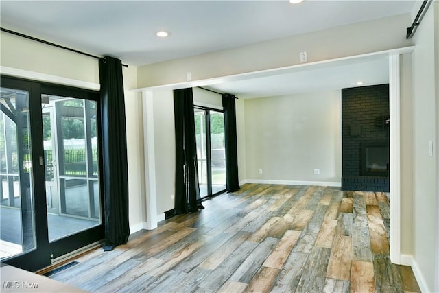 191 Maple Leaf Dr, Hubbard, OH 44425 - empty room featuring healthy amount of natural light, wood finished floors, a brick fireplace, and recessed lighting