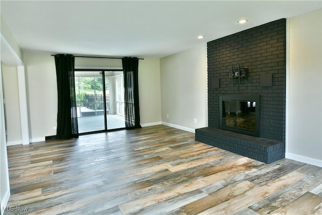191 Maple Leaf Dr, Hubbard, OH 44425 - unfurnished living room with wood finished floors, a brick fireplace, and recessed lighting