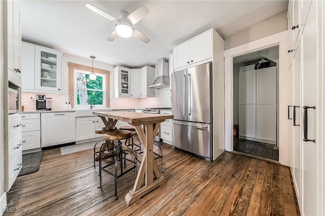 128 Forest Hill Dr, Avon Lake, OH 44012 - kitchen featuring appliances with stainless steel finishes, wall chimney exhaust hood, backsplash, and dark wood finished floors