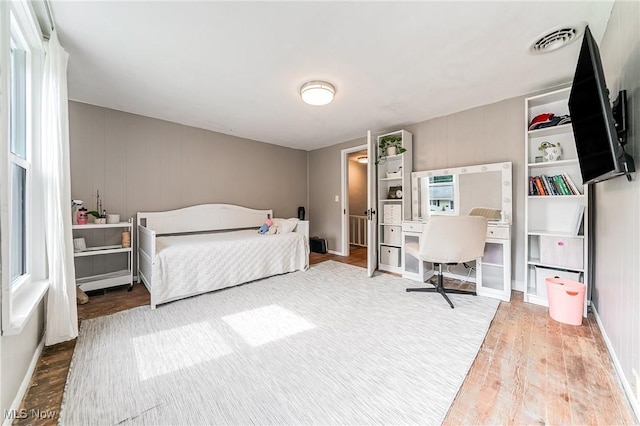 128 Forest Hill Dr, Avon Lake, OH 44012 - bedroom featuring wood finished floors and a decorative wall