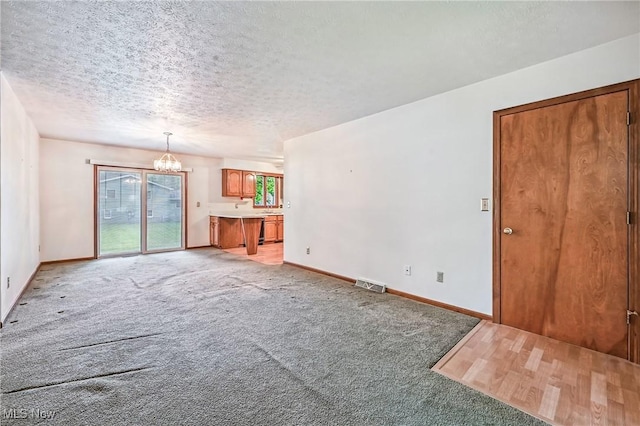 114 Corrin Cir, Cortland, OH 44410 - unfurnished living room featuring a chandelier, light colored carpet, and a textured ceiling