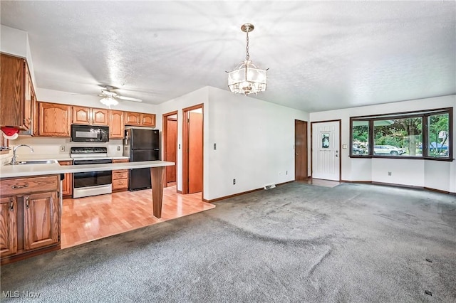 114 Corrin Cir, Cortland, OH 44410 - kitchen with black appliances, light colored carpet, light countertops, a chandelier, and a textured ceiling